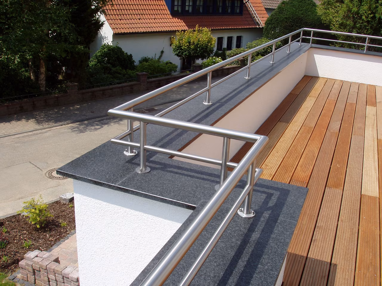Edelstahlgeländer an einer Terrasse mit Holzbelag